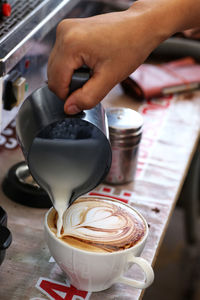 Cropped image of hand holding coffee cup