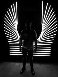 Full length portrait of young man standing at night