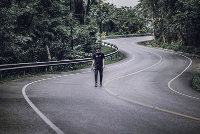 Rear view of man riding motorcycle on road