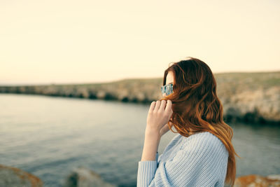 Portrait of woman against sea against sky