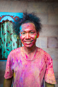 Portrait of young man covered with powder paint during holi