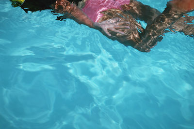 Low section of woman swimming in pool