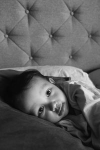 Close-up portrait of cute baby boy lying on bed