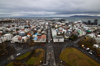 High angle view of townscape by sea against sky