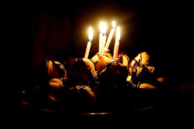 Close-up of burning candles in darkroom