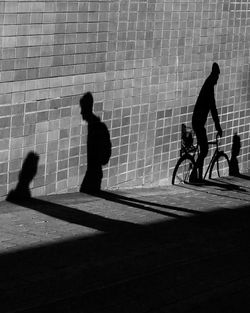 Silhouette people walking on footpath