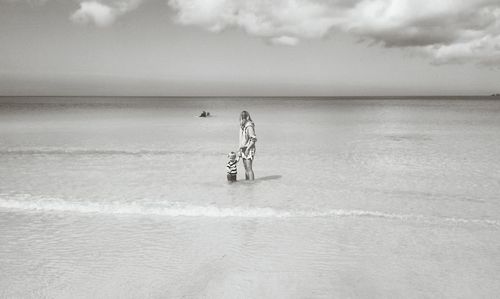 Mother and child standing in sea