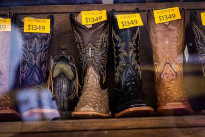 Cowboy boots and leather belts in a business showcase . saddlery, footwear and accessories.