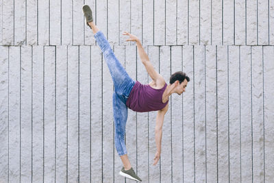 Side view of man skateboarding on wall