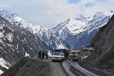 People on snow covered mountain against sky