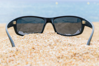 Close-up of sunglasses on beach