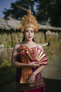 Portrait of young woman wearing traditional clothing standing on land