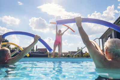 Group of seniors with trainer doing water gymnastics in pool