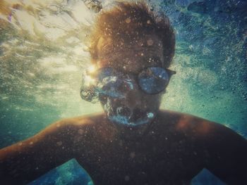 Portrait of young man swimming in pool