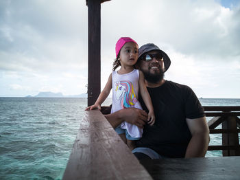  family relaxing . father and toddler sitting on deckchair chalet resort. summer vacation idea.