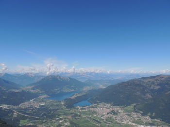 Aerial view of landscape and mountains against blue sky