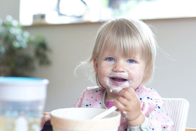 Cheerful cute girl eating ice cream at home