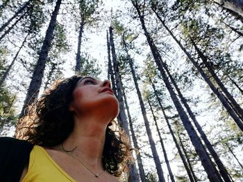 Low angle portrait of young woman in forest