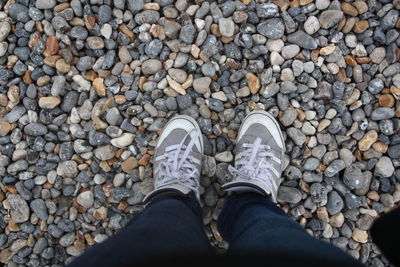 Low section of person standing on pebbles