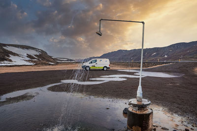 Hot shower station from geothermal power at krafla against van during sunset