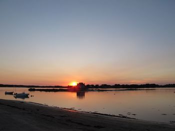 View of boats in calm lake at sunset