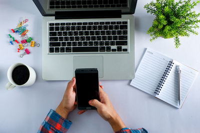 High angle view of woman using mobile phone on table