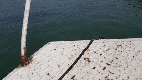 High angle view of birds perching on retaining wall by sea