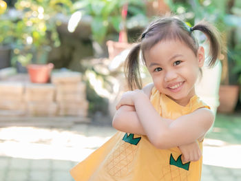 Positive charming 4 years old cute baby asian girl, little child with adorable pigtails hair smiling