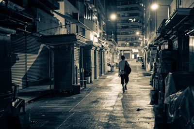 Rear view of man walking in alley