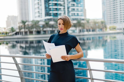 A business woman looks through documents during a break on the street