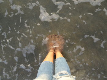 Low section of woman standing on beach