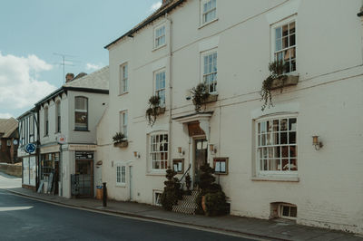 Residential building by street against sky