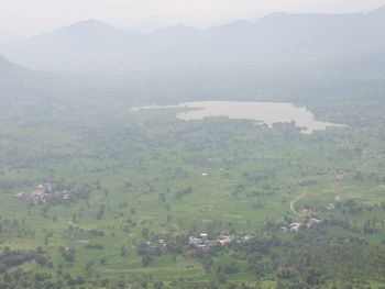 High angle view of field and mountains against sky