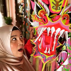 Woman wearing hijab looking at chinese dragon