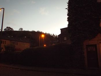 Illuminated building against sky at sunset