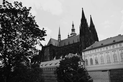 Low angle view of trees and buildings against sky
