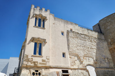 Low angle view of old building against clear blue sky