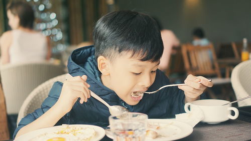 Boy eating food in restaurant