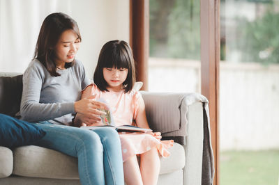 Mother and girl sitting at home