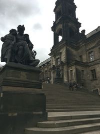 Low angle view of statues on building against sky