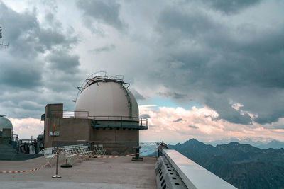 View of communications tower against cloudy sky