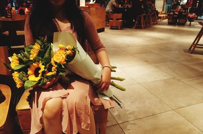 Midsection of woman holding flower bouquet