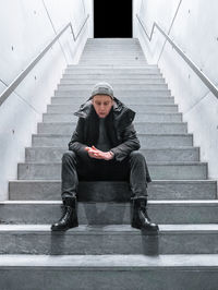 Portrait of man sitting on staircase