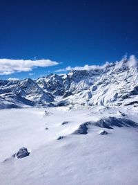 Scenic view of snowcapped mountains against cloudy sky