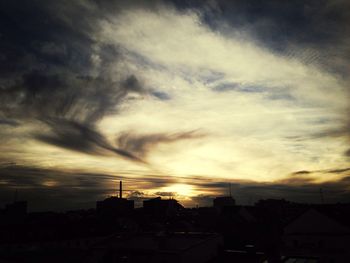 Buildings against cloudy sky at sunset