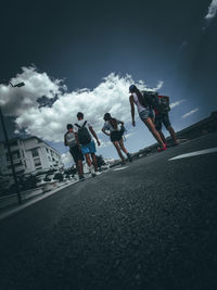 People on road against sky in city