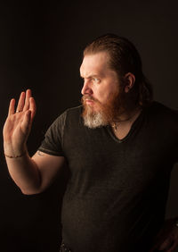 Midsection of man standing against black background