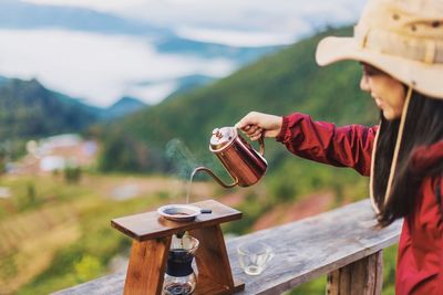 Woman making coffee on railing