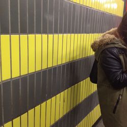 Rear view of woman standing on railroad station platform