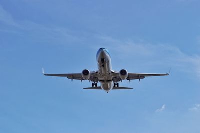 Low angle view of airplane against cloudy sky